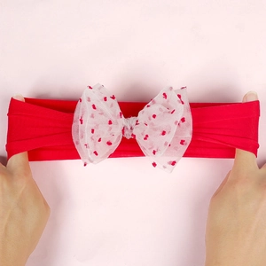 Detail of red baby nylon headband showing high elasticity and red heart mesh bow
