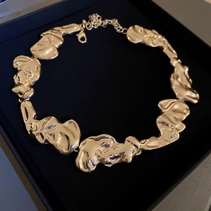 Detailed view of an irregular gold-plated lava necklace inside a black gift box