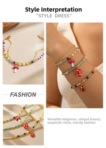 Détail de bracelets perlés avec breloques fraise, champignon et coccinelle en or
