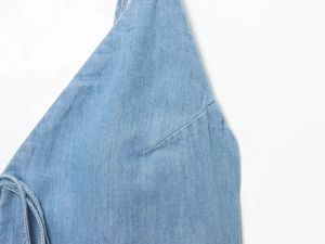 Close-up of blue denim midi dress showing stitching detail and strap attachment