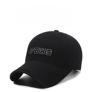 Close-up of FBXS embroidery and distressed brim on a black cotton baseball cap