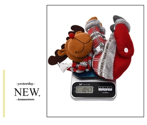 Détail d'une attache de rideau de Noël renne en peluche sur une balance pesant 104,7g