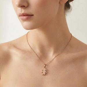 Detailed close-up of a rose gold necklace with a girl silhouette pendant on a model