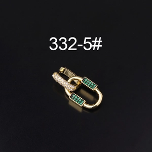 Macro shot of interlocking gold rings with green crystals and white zircon stones