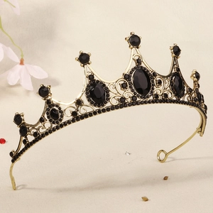 Detail of vintage golden crown featuring oval black stones and baroque floral engravings