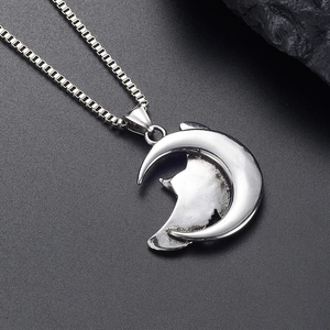 Detailed shot of silver crescent moon and wolf head pendant with vintage stainless steel chain