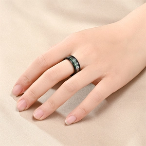Close-up detail of a men's black titanium steel ring with a green dragon pattern.