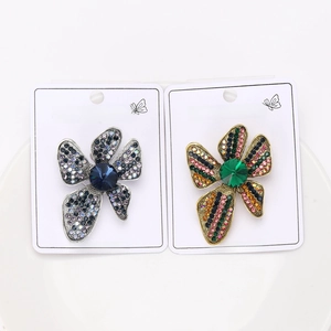Detail of silver and gold flower brooches with colorful rhinestones on display cards