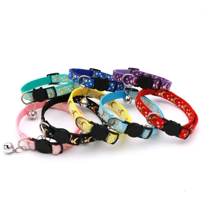 Close-up of colorful cat collars with gold star and moon prints and silver bells