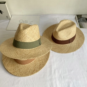 Detail of woven raffia sun hats showing fine texture and three colored grosgrain bands