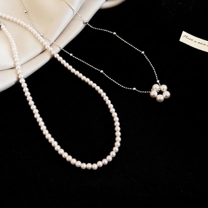 French vintage multi-layer pearl necklace with silver flower pendant on silk background
