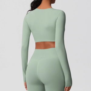 Vue arrière de l'ensemble de yoga vert clair avec haut court à manches longues et legging