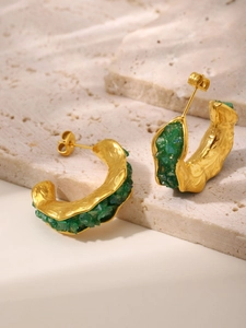 Detailed close-up of C-shaped gold earrings featuring green crushed crystal stone inlay