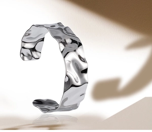 Macro detail of silver wide cuff bracelet with irregular hammered wave texture