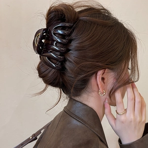 Dark brown acrylic pumpkin striped shark clip for thick hair shown on a woman back view