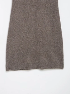 Macro detail of the camel knitted dress hem showing thick wool texture and stitching