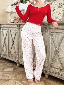 Detail of red ribbed pajamas with V-neck lace trim and white decorative buttons