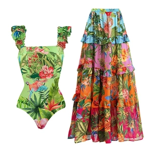 Tropical floral print swimwear set featuring ruffled one-piece and layered maxi skirt