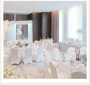 Grand banquet setup with white chair covers, floral centerpieces and silver balloons