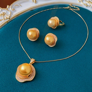 Macro view of vintage jewelry set with golden pearls and zircon on velvet