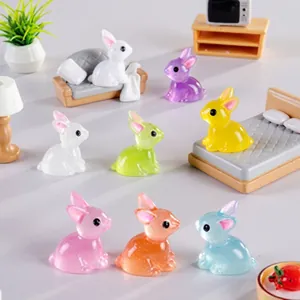 Close-up of colorful translucent resin rabbit figurines in miniature home scenes