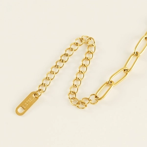 Close-up of golden titanium steel paperclip chain with S.STEEL engraved tag for women