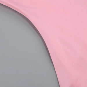 Detailed close-up of the smooth pink fabric texture and precise curved stitching on the dress