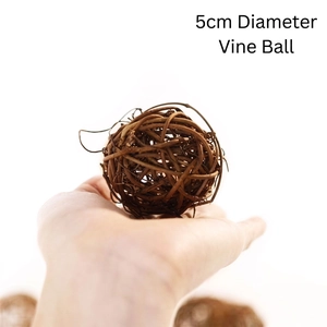 Detailed view of a 5cm natural woven vine ball held by hand for scale comparison