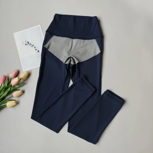 Flat lay of high-waist navy yoga leggings with grey triangle patchwork detail
