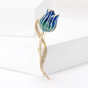 Detail of tulip brooch with blue-green enamel petals and crystal accents on gold stem