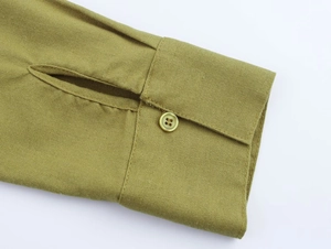 Detail of olive green linen shirt cuff featuring a single button and woven texture