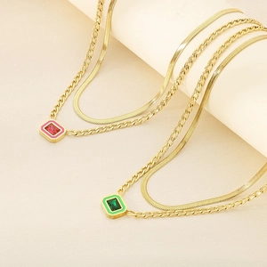 Double-layered gold chain necklace with emerald green and ruby red rectangular pendants