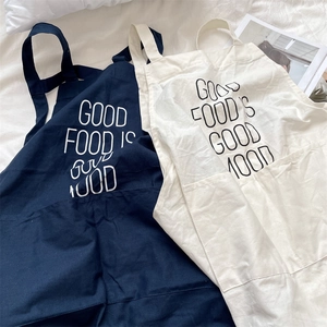 Detail of cotton linen aprons showing fabric texture and 'GOOD FOOD' slogan print