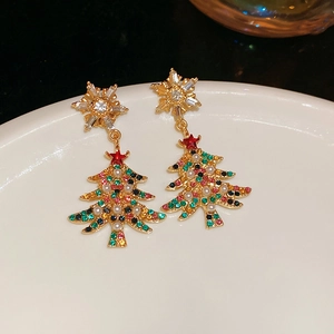 Detailed close-up of gold Christmas tree earrings with colorful crystals and pearl tassel