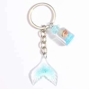 Ocean mermaid keychain with blue glitter gradient fish tail and tiny shell glass bottle