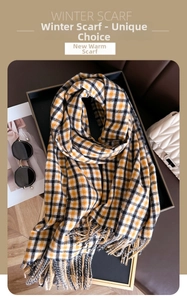Detailed view of yellow and black plaid cashmere-feel scarf with soft fringe tassels