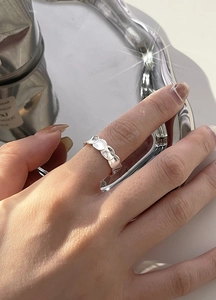 Primer plano de un anillo de plata de ley S925 con textura de concha en el dedo