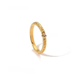 Detail view of 3mm wide hammered 18K gold ring featuring a rectangular zircon setting
