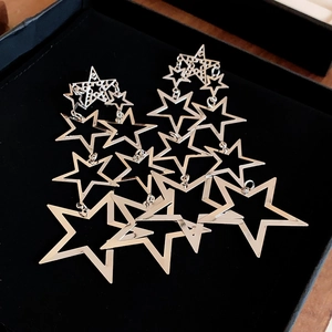Gros plan de boucles d'oreilles étoiles en argent avec pampilles dans un écrin noir