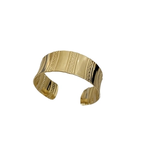 Minimalist gold metal cuff bracelet featuring vertical textured patterns on white background