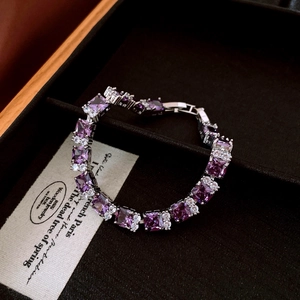 Detailed shot of square purple gemstones and white zircons set in a silver metal bracelet