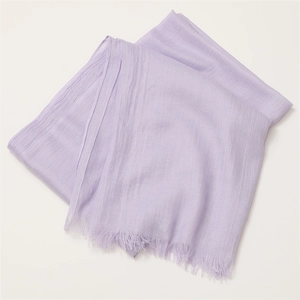 Detailed close-up of a purple linen cotton scarf with frayed edges and soft texture