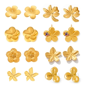 Exaggerated golden flower stud earrings in various floral designs on white background