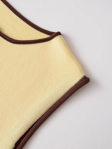 Détail de la couture contrastée du col rond d'un haut en tricot sans manches jaune