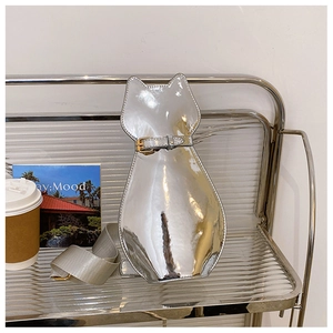 Detail of silver mirror cat-shaped crossbody bag with metallic strap on display