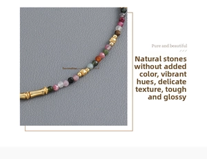 Detailed macro view of colorful tourmaline beaded necklace with gold brass heart pendant