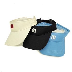 Detail of embroidered 'm' logo on cotton sun visors in beige, black, and blue colors