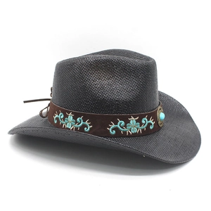 Detail of dark brown cowboy straw hat with turquoise embroidery on a faux suede band