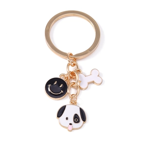 Cartoon dog and bone keychain with golden ring and smile charm on white background