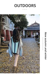 Rear view of a model wearing a retro ethnic knit shawl with wavy patterns in a town